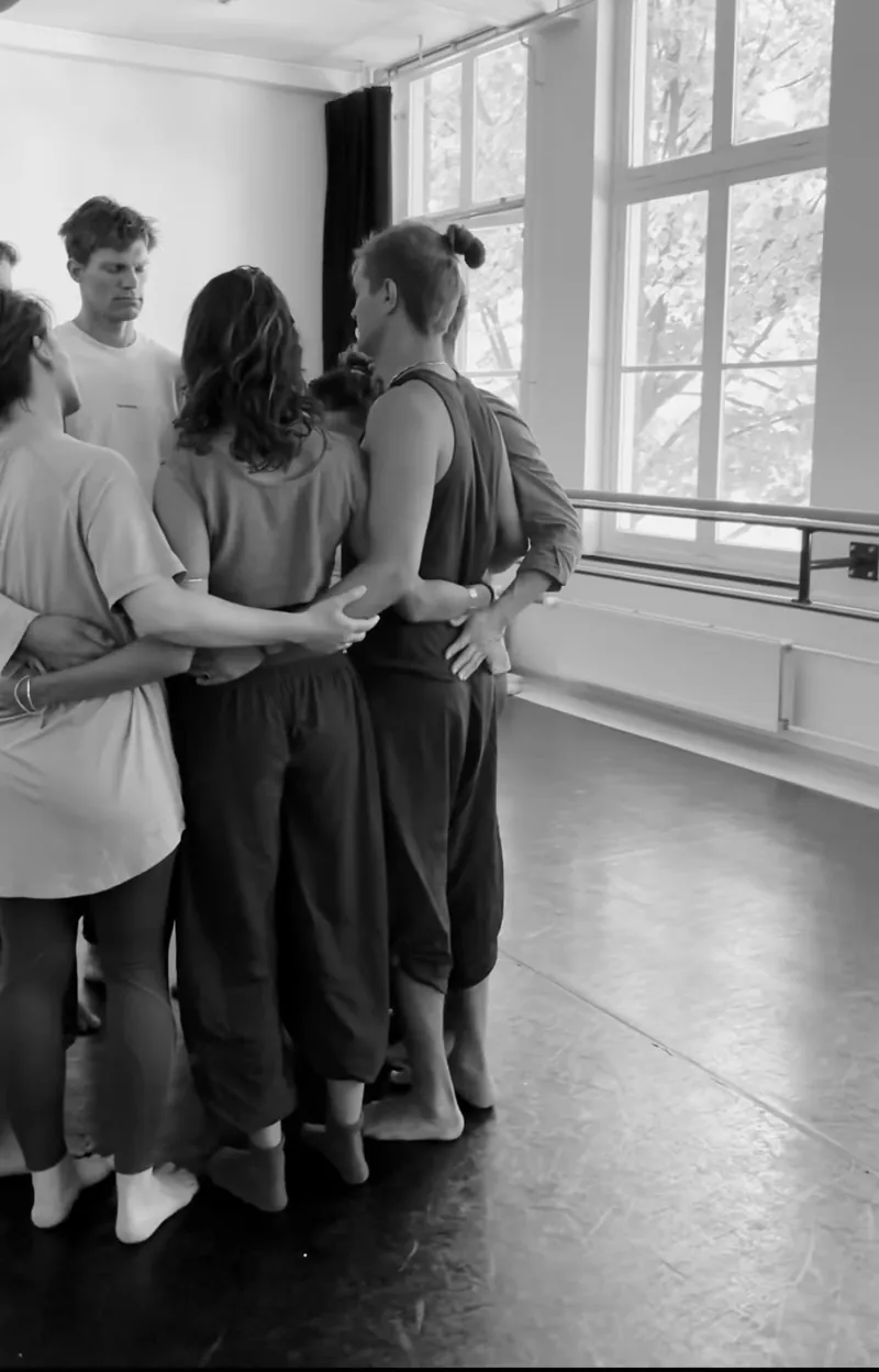 Participants standing in a circle with their arms around each other