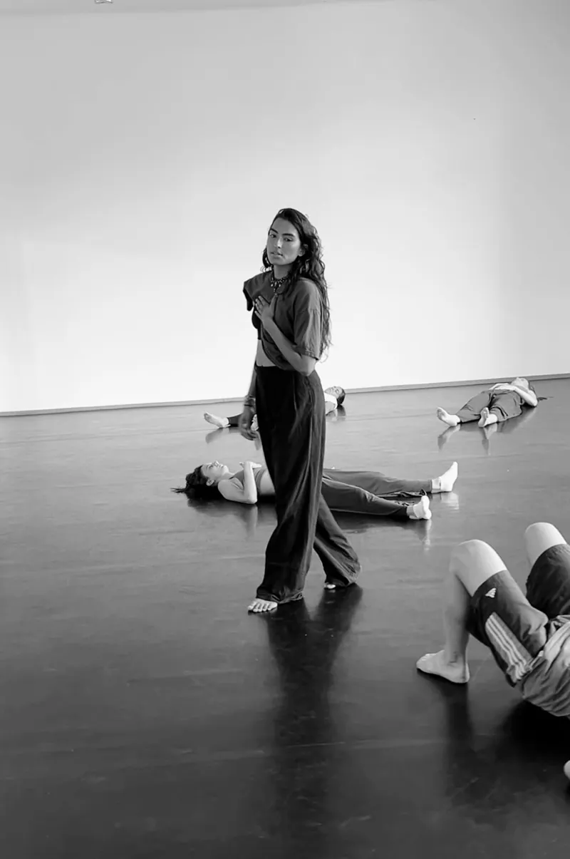 Reena walking through the studio among participants lying down