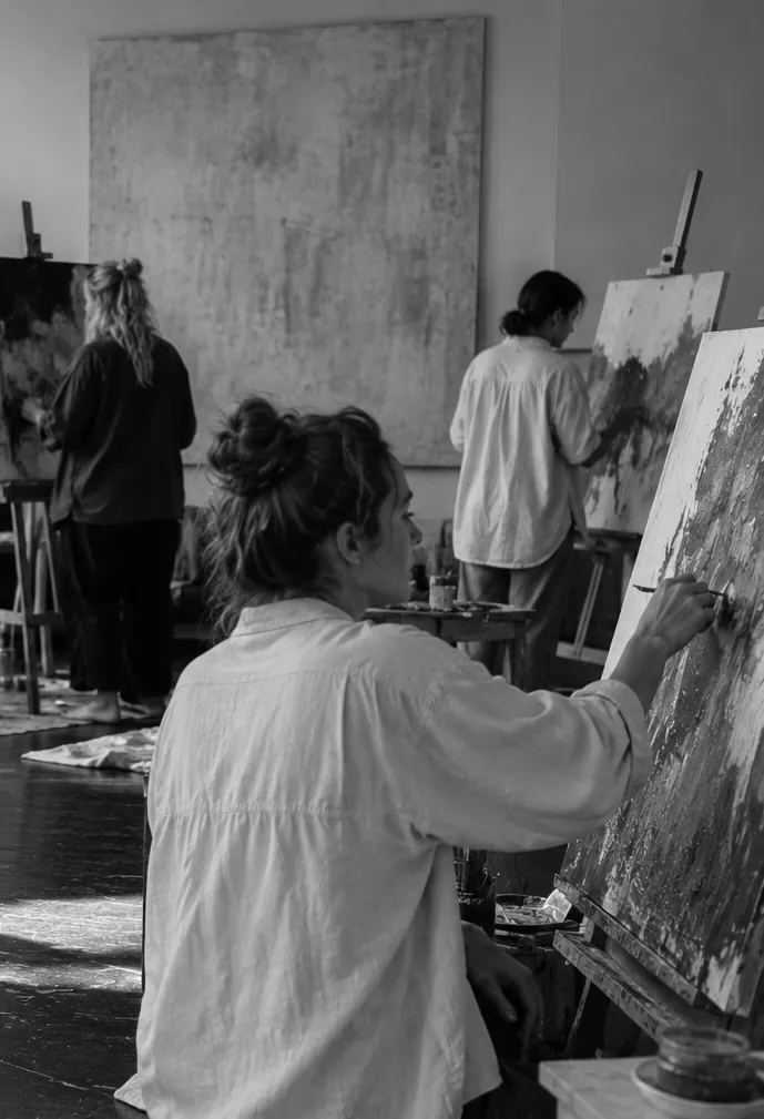 A participant painting on a large canvas in the studio